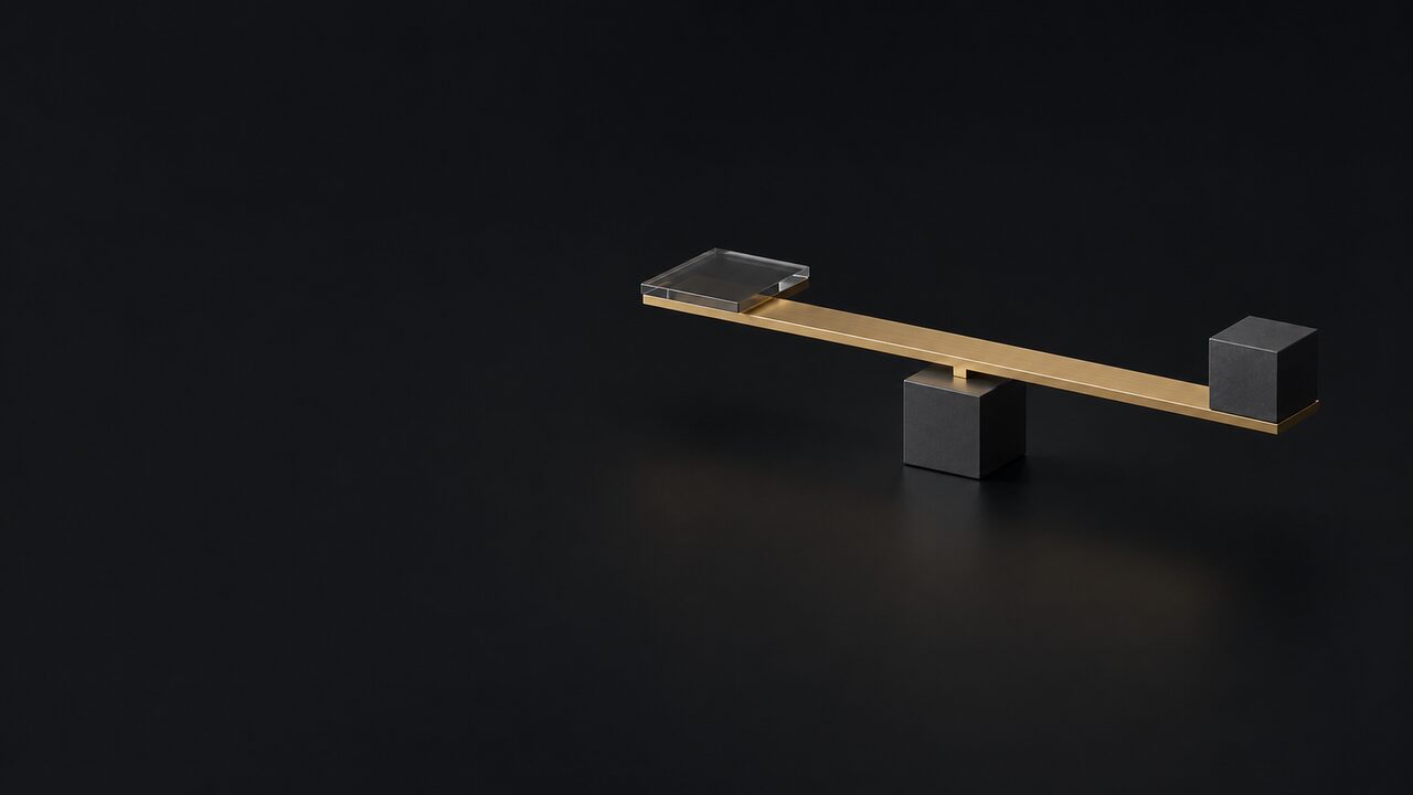 A brass bar resting on a single pivot between a glass tile and a graphite cube